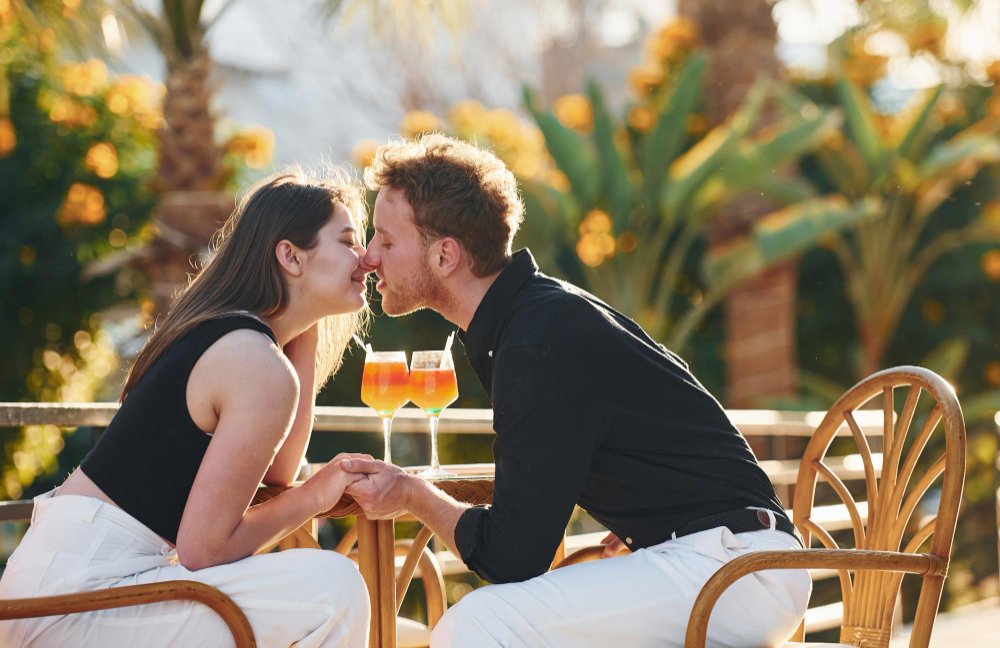 Couple sharing a warm moment over drinks outdoors